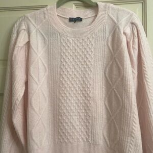 Pale, soft pink cable knit sweater.